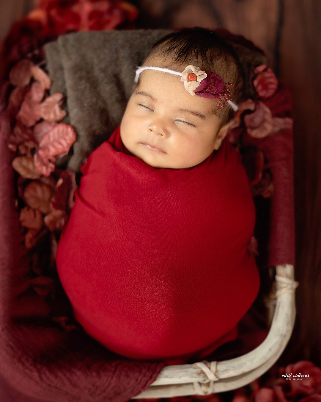 Newborn wrapped in red, basket portrait